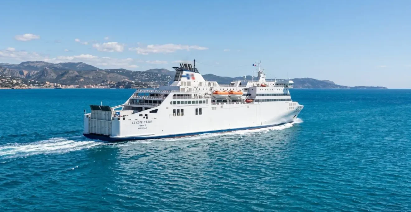 Un ferry moderne naviguant en pleine mer Méditerranée sous un ciel dégagé, eaux bleues turquoise, architecture navale contemporaine