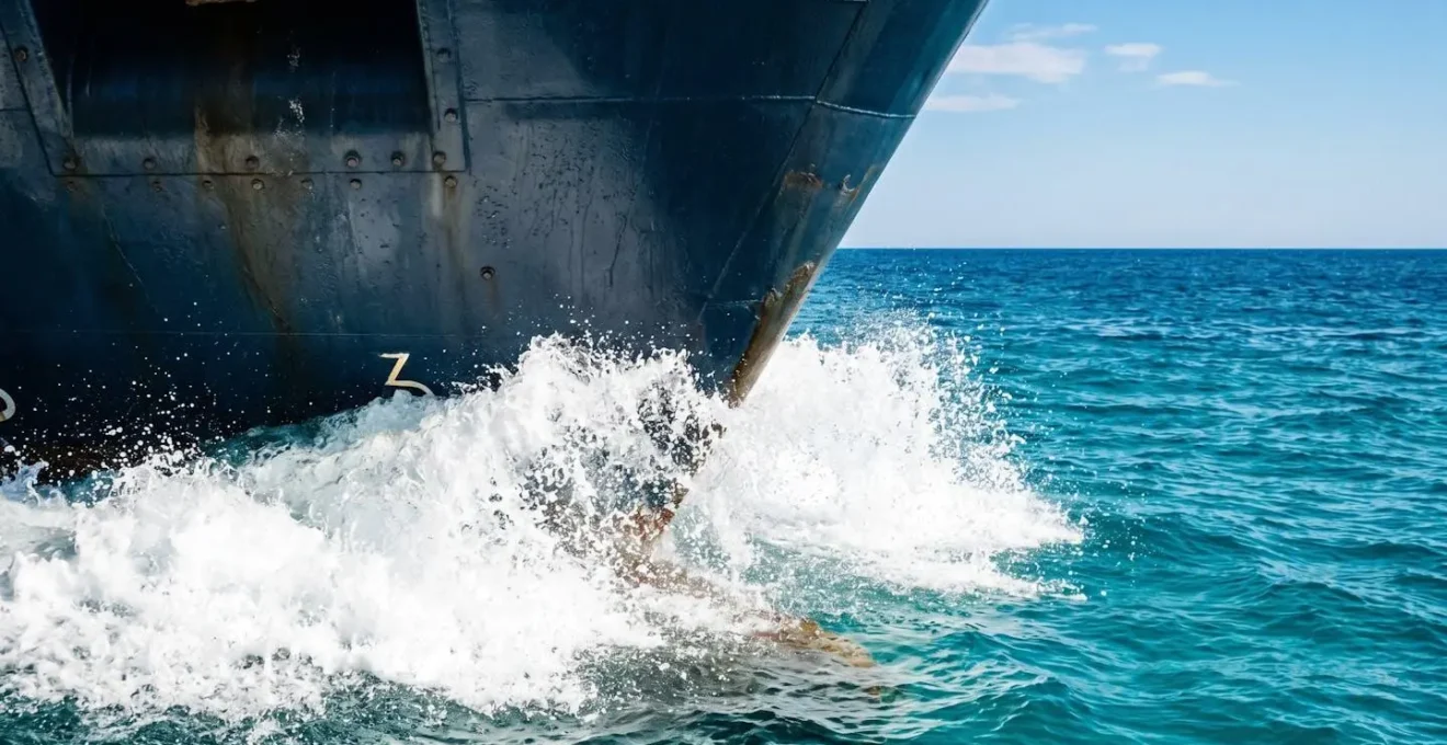 Proue d'un ferry moderne fendant les eaux turquoise de la Méditerranée sous un ciel bleu lumineux