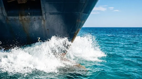 Proue d'un ferry moderne fendant les eaux turquoise de la Méditerranée sous un ciel bleu lumineux